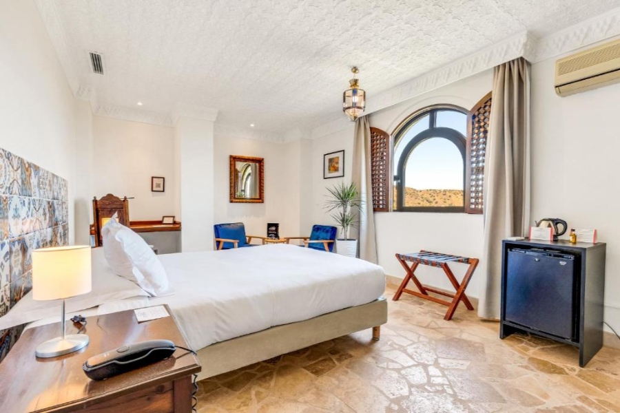 Hotel room in Castillo de Monda, Spain, featuring a bed, desk, and chair in a cozy setting.