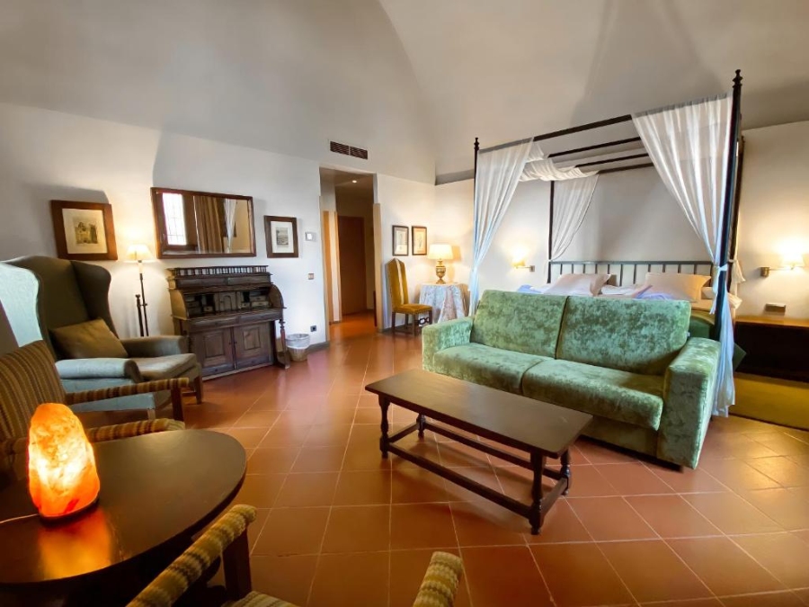 Interior view of a Parador de Cardona room, showcasing a bed, couch, and table in a welcoming setting.