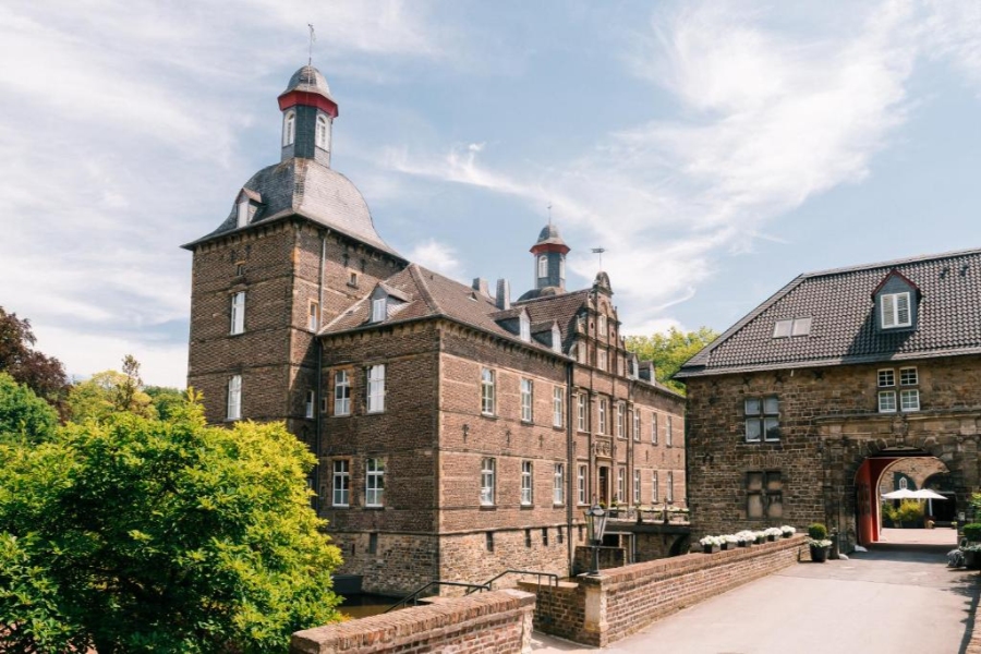Panoramic view of Schlosshotel Hugenpoet, a historic castle in Amsterdam, showcasing its elegant architecture and surrounding gardens